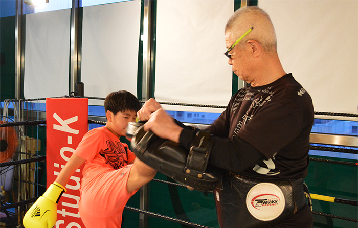 キックをする会員様とミットを受けるインストラクター